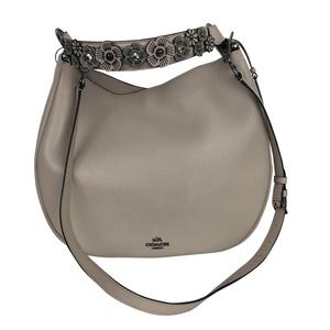 Coach handbag with flower embellished strap.